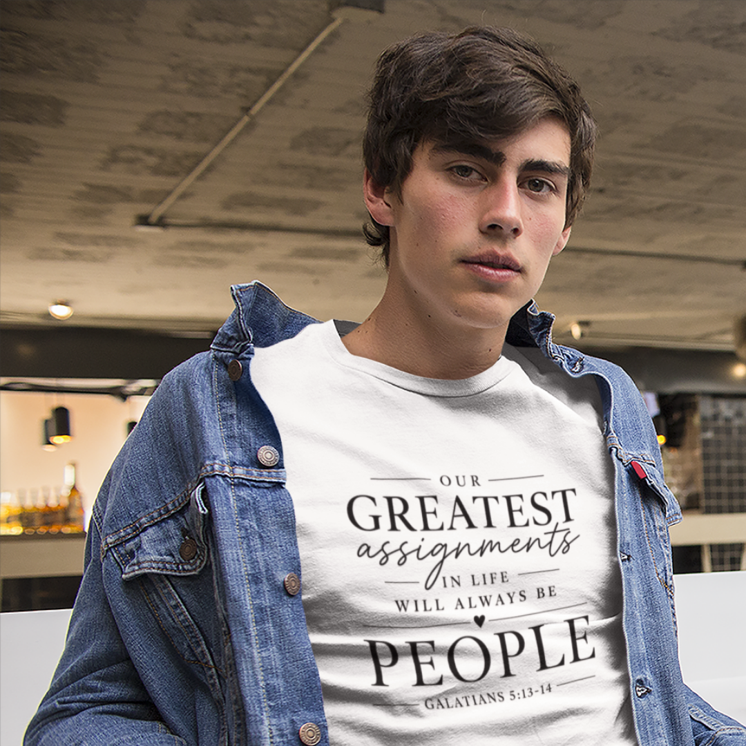 Person wearing a white t-shirt with a motivational quote, standing indoors.