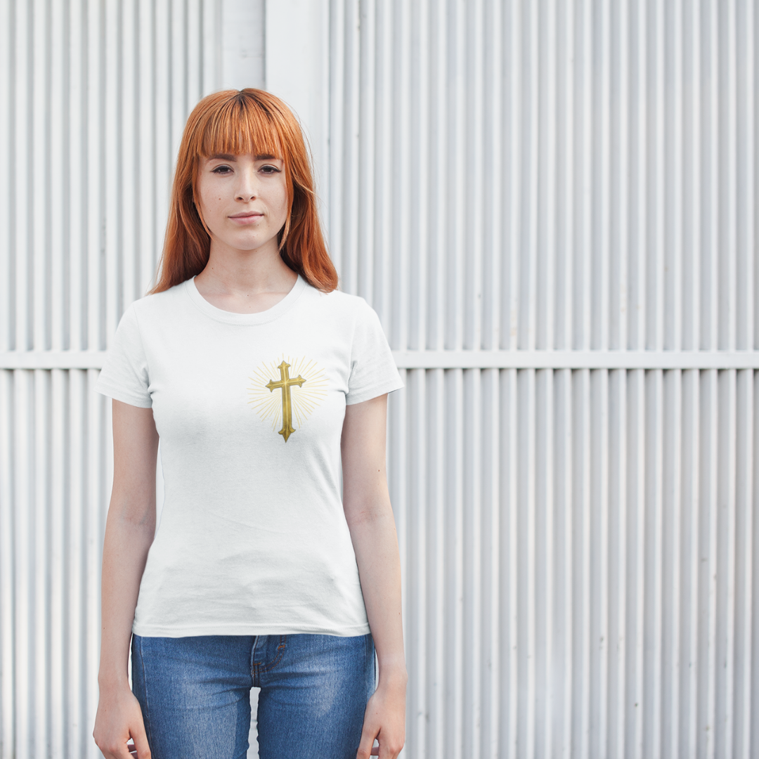 Person wearing a white t-shirt with a gold cross design against a corrugated metal background