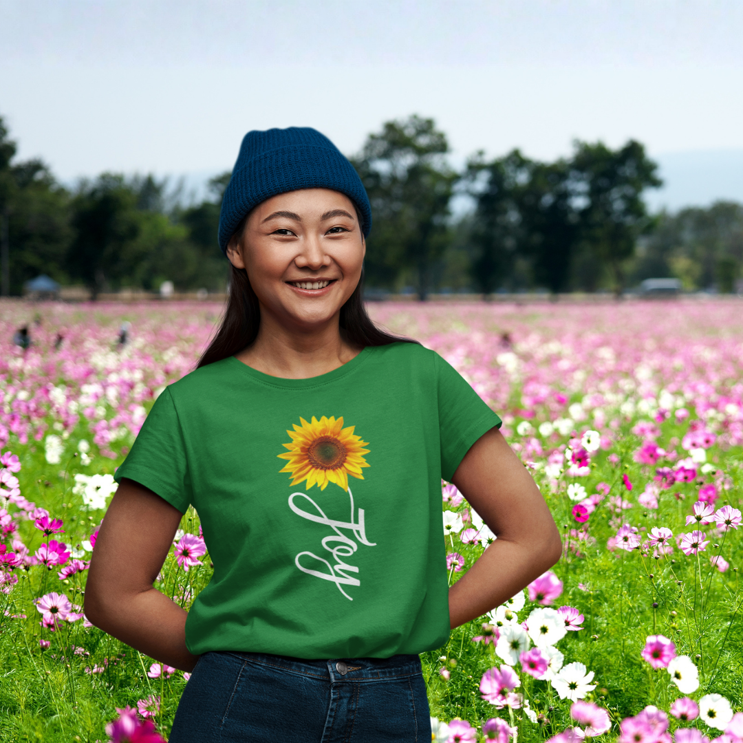 Person wearing a green t-shirt with a sunflower design in a field of flowers