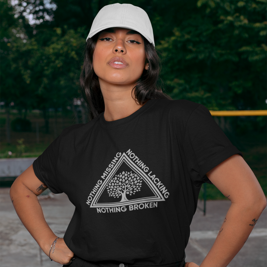 Person wearing a black t-shirt with a tree design and text, standing outdoors.