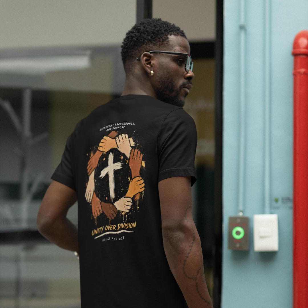 Man wearing a black t-shirt with a graphic design on the back, standing in an urban setting.